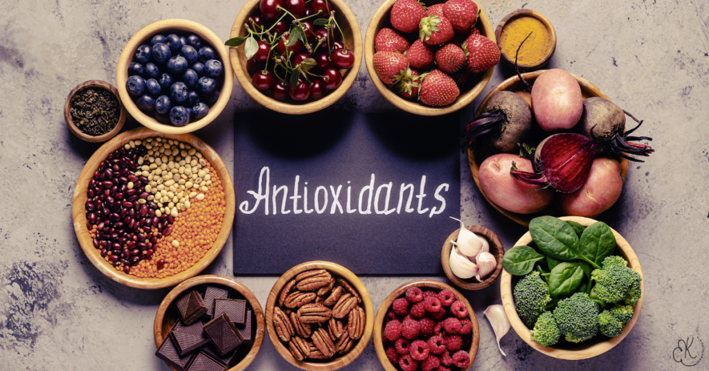 Frutas, vegetais, oleaginosas e legumes ao redor da palavra “Antioxidants”